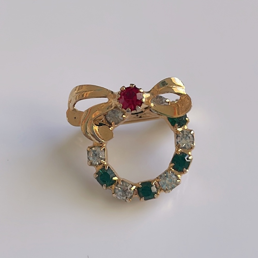 Holiday Wreath Brooch in gold color with red, green and clear gemstones.